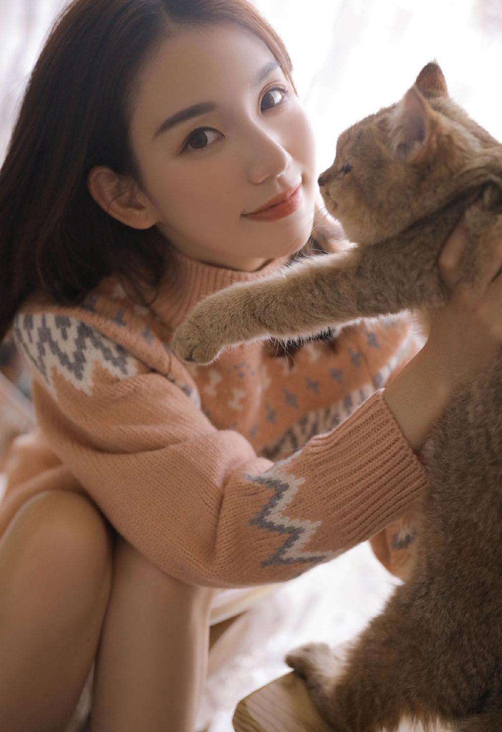 甜美杏眼高中女生粉嫩毛衣逗猫精选图片